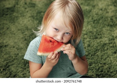 Funny Little Girl Eating Watermelon Close-up. Cute Child With Watermelon Indoors. Concept Of Healthy Food, Summertime. Copy Space