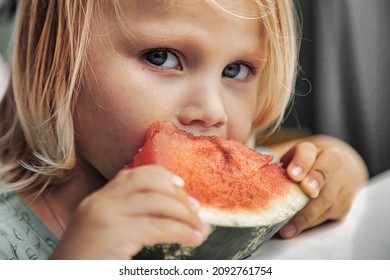 Funny Little Girl Eating Watermelon Close-up. Cute Child With Watermelon Indoors. Concept Of Healthy Food, Summertime. Copy Space