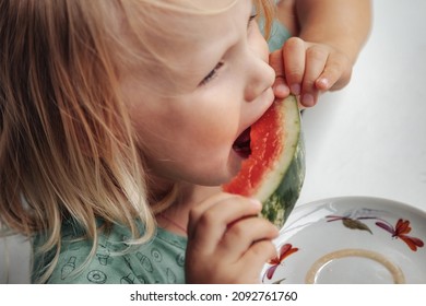 Funny Little Girl Eating Watermelon Close-up. Cute Child With Watermelon Indoors. Concept Of Healthy Food, Summertime. Copy Space