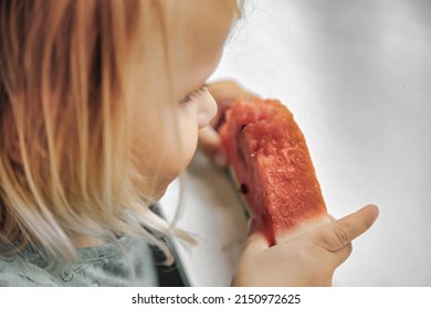 Funny Little Girl Eating Watermelon Close-up. Cute Child With Watermelon Indoors. Concept Of Healthy Food, Summertime. Copy Space