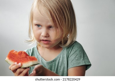 Funny Little Girl Eating Watermelon Close-up. Cute Child With Watermelon Indoors. Concept Of Healthy Food, Summertime. Copy Space