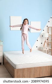 Funny little girl jumping on bed