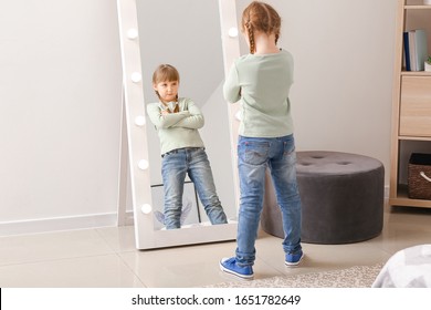 Funny Little Girl Looking In Mirror At Home