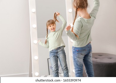 Funny Little Girl Looking In Mirror At Home