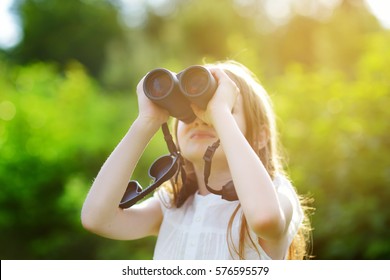 Funny Little Girl Looking Through Binoculars On Sunny Summer Day 