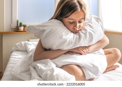 Funny little girl with a pillow in bed early in the morning wants to sleep. - Shutterstock ID 2222016005