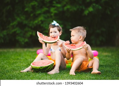 Funny little kids brother and sister eating watermelon on green grass near inflatable pool in yard at home. Toddler boy and girl. Children eat fruit in garden. Childhood, Family, Healthy Diet. - Powered by Shutterstock