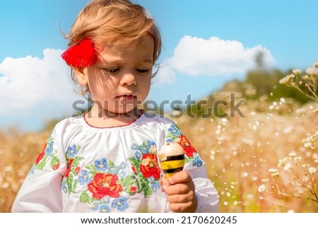 Funny little Ukrainian Caucasian girl in a shirt with embroidery playing in nature where wild flowers. Out of city. Summer. Tradition and religion concept
Ukraine