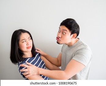 Funny lovely Asian couple trying to kiss each other. Concept of comedy love.
