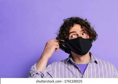 Funny Male Putting  Corona COVID-19 And SARS Mask On Face And Looking  Sideways.