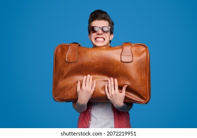 Funny Male Tourist In Sunglasses Holding Heavy Baggage And Showing Concept Of Summer Vacation And Size Allowance