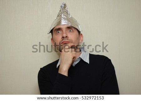 Funny man in a cap of aluminum foil. Concept art phobias.