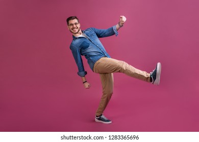 Funny man in casual is having some fun. He is posing and dancing. Isolated on pink background - Shutterstock ID 1283365696