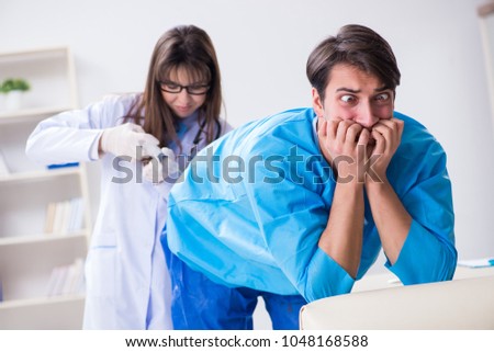 Funny man getting ready for buttocks syringe shot