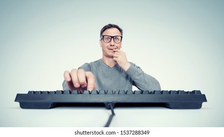 Funny Man In Glasses With A Crafty Look Presses A Button On The Keyboard