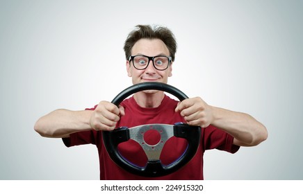 Funny man in glasses with a steering wheel, car drive concept 