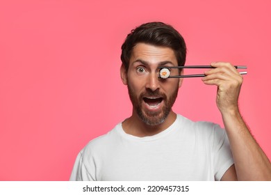 Funny Man Hiding His Eye With Tasty Sushi Roll On Pink Background. Space For Text