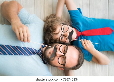 Funny Man And Kid With Fake Mustache. Happy Family Playing In Home 