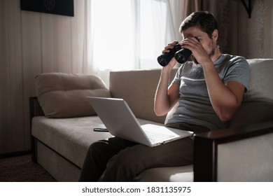 Funny Man Looking Searching Binoculars A Laptop On The Table Working At Home Office. Job Search Online. Searching Idea And Concept