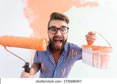 Funny man with painting roller indoors. Redecoration, renovation, apartment repair and refreshment concept.
