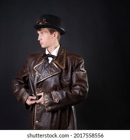 Funny Man In A Ridiculous Leather Coat And A Top Hat, Vintage Style Of Clothing, Photo On A Black Background