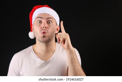 Funny Man In A Santa Hat On A Black Background.