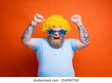 Funny man with wig and sunglasses is happy and exults for something