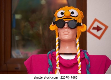 Funny mannequin in a headdress and dark safety glasses on display.                               