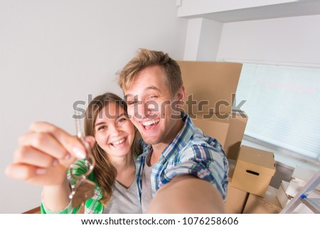 Funny married couple with boxes and holding flat keys