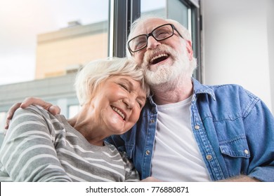 Funny memories. Waist up portrait of old happy man and woman remembering sweet moments while smiling with closed eyes