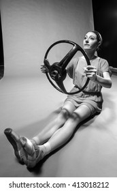 Funny Modern Ballet Dancer Posing With Car Steering Wheel In Studio.