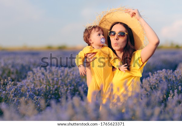 Funny Mom and Baby\
Sitting in Lavender Field. Cute daughter traveling with mother to\
the countryside\
