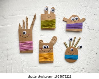 Funny monsters made of cardboard recycling and colored yarn, kids craft. An idea for a DIY project.