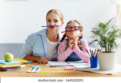 Funny Mother And Child Daughter Doing Homework Writing And Reading At Home
