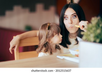 Funny Mother And Daughter Celebrating At Fast Food Birthday Party. Mom Stealing French Fries So Her Child Won’t Eat Junk Food In A Restaurant 