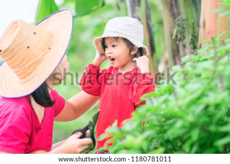 Funny mother and daughter talk and laughing on gardening fields. Asian mom picking  and extirpation cutting control for plant disease. Adorable girl be calling and joyful with her mum.