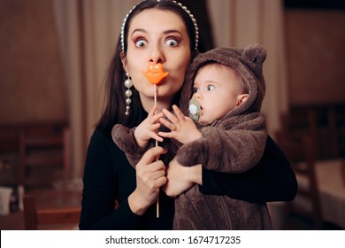 Funny Mother with Party Accessory Holding Baby. Silly quirky millennial mom having a sense of humor
