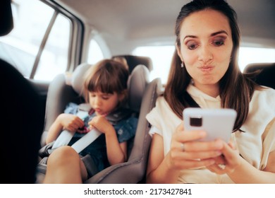 
Funny Mother Texting During Family Car Ride Trip. Mom And Daughter Traveling Together Trying To Find Distractions During Long Road To Destination
