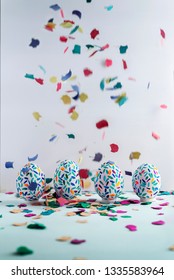 Funny Multicolored Easter Eggs Hand Painted And Splash Of Colorful Papers In Movement. Easter Background. No People