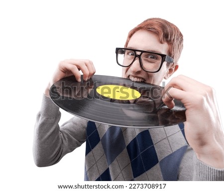 Funny nerd guy with big glasses, he is holding a vinyl record and biting it