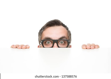 Funny nerd peeking from behind the desk isolated on white background with copy space - Powered by Shutterstock