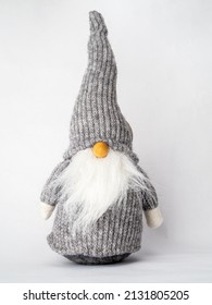 Funny nordic gnome toy ornament with long beard and orange nose isolated on a white background