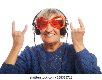 Funny old lady listening music and showing thumbs up. Isolated on white. 