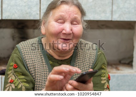 funny old woman uses a mobile phone