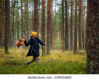 Funny One Person Searching For A Mushrooms In An Autumn Deep Forest. Mushroomer With A Basket In A Woods