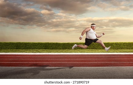 Funny overweight man speeding on the running track with copy space