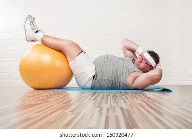 Funny overweight man working out on the floor