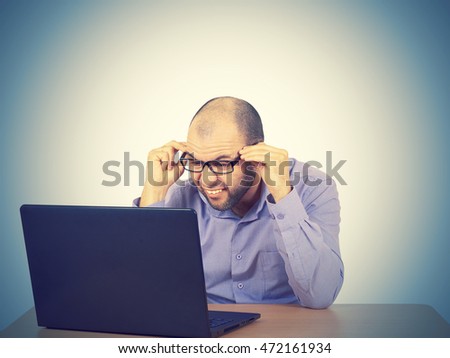 Funny photo of businessman bald with beard wearing shirt and glasses.  angry businessman working with laptop at table. Isolated on  background 