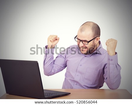 Funny photo of businessman bald with beard wearing shirt and glasses.  angry businessman working with laptop at table. Isolated on white background 