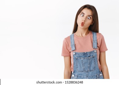 Funny, playful cute girlfriend not scared showing her hilarious side, playing charades, mimicking fish, folding lips and squinting shifting eyes, standing white background upbeat, grimacing - Shutterstock ID 1528836248